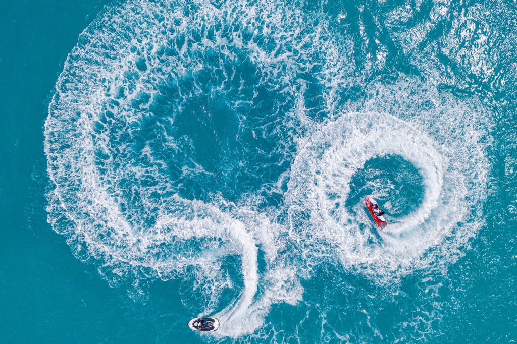 People Are Playing A Jet Ski In The Sea. Aerial View. Top View.